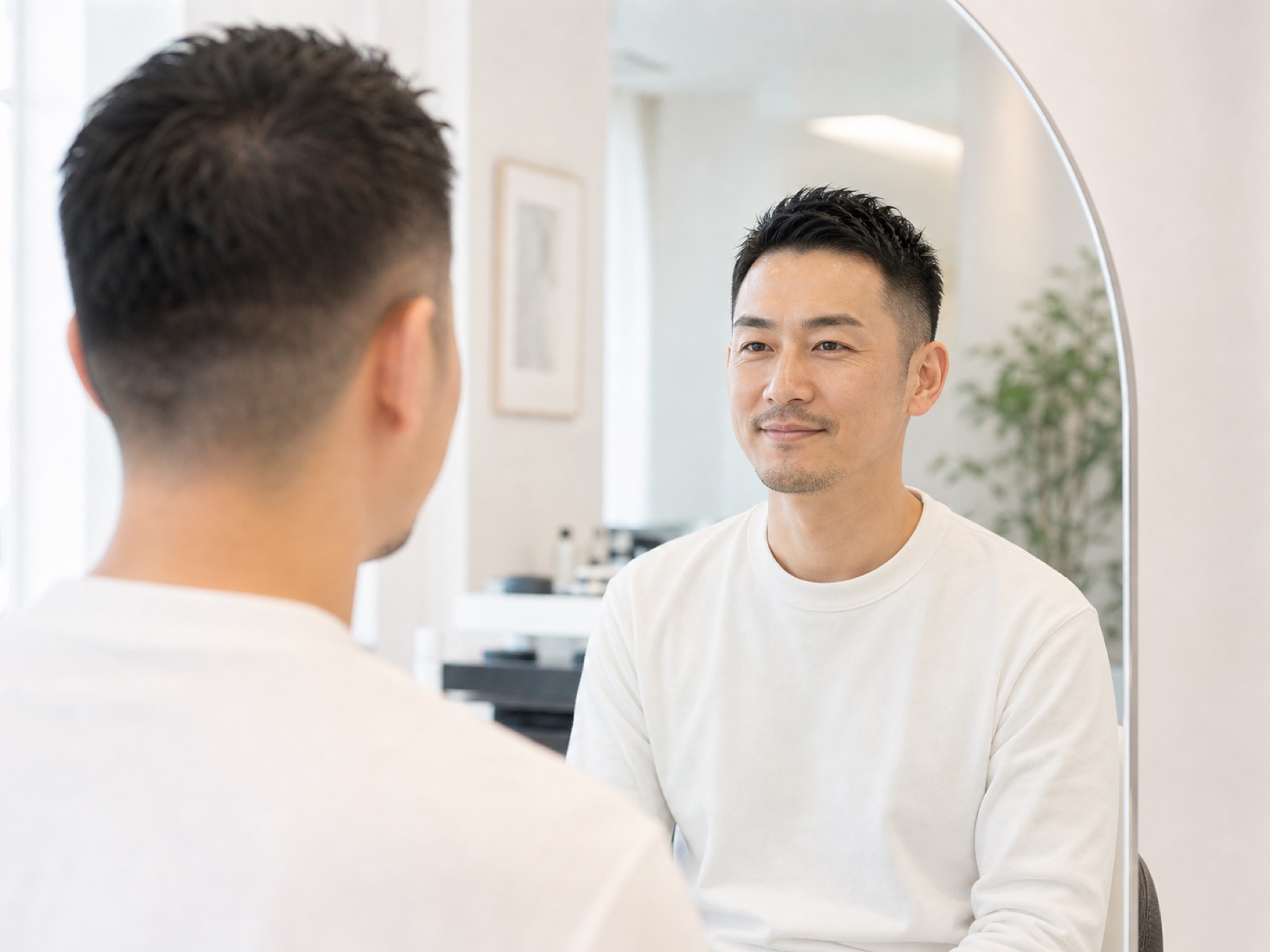 鏡を見て自然に笑う男性